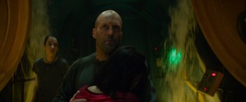 Movie still from “Meg 2: The Trench” (2023), directed by Ben Wheatley – A man holding a woman in his arms in a dark room; Close Up shot, Low angle