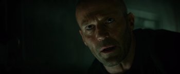 Movie still from “Meg 2: The Trench” (2023), directed by Ben Wheatley – A bald man with a goatee stares into the camera; Close Up shot, Low angle