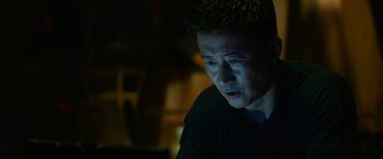 Movie still from “Meg 2: The Trench” (2023), directed by Ben Wheatley – A person sitting at a table; Close Up shot, Low angle