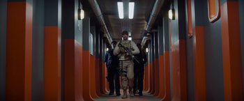 Movie still from “Meg 2: The Trench” (2023), directed by Ben Wheatley – A man with a gun walking down a hallway with two other men; Wide shot, Low angle
