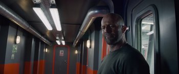 Movie still from “Meg 2: The Trench” (2023), directed by Ben Wheatley – A man with a beard is standing in a room; Medium shot, Low angle