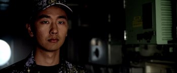 Movie still from “Megalodon Rising” (2021), directed by Brian Nowak – A person wearing a hat; Close Up shot, Over the shoulder angle