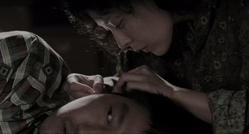 Movie still from “Memories of Murder” (2003), directed by Bong Joon Ho – A man and a woman are looking at each other; Close Up shot, Overhead angle