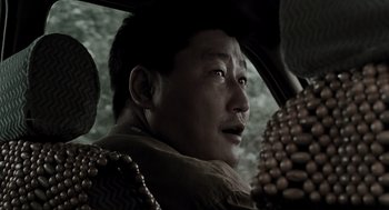Movie still from “Memories of Murder” (2003), directed by Bong Joon Ho – A man sitting in a car looking out of the window; Close Up shot, Low angle
