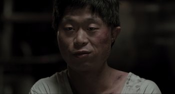 Movie still from “Memories of Murder” (2003), directed by Bong Joon Ho – A person wearing a white t - shirt; Close Up shot, High angle