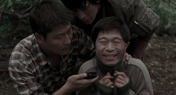 Movie still from “Memories of Murder” (2003), directed by Bong Joon Ho – A group of men standing next to each other; Close Up shot, High angle
