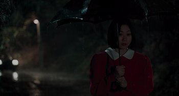 Movie still from “Memories of Murder” (2003), directed by Bong Joon Ho – A woman holding an umbrella in the rain; Medium shot, Low angle