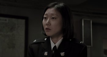 Movie still from “Memories of Murder” (2003), directed by Bong Joon Ho – A woman in a military uniform looking to her left; Close Up shot, Low angle