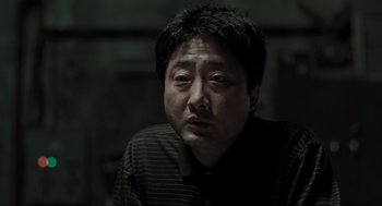 Movie still from “Memories of Murder” (2003), directed by Bong Joon Ho – A person wearing a black shirt; Close Up shot, Low angle
