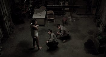 Movie still from “Memories of Murder” (2003), directed by Bong Joon Ho – A group of young men sitting on the ground; Wide shot, High angle