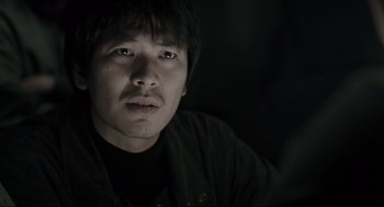 Movie still from “Memories of Murder” (2003), directed by Bong Joon Ho – A person wearing a black shirt; Close Up shot, Low angle