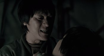 Movie still from “Memories of Murder” (2003), directed by Bong Joon Ho – A young man with short black hair is holding a woman's arm; Close Up shot, Over the shoulder angle
