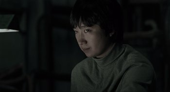 Movie still from “Memories of Murder” (2003), directed by Bong Joon Ho – A young person is looking into the distance; Close Up shot, Low angle