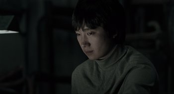 Movie still from “Memories of Murder” (2003), directed by Bong Joon Ho – A young man sitting in front of a window; Close Up shot, Low angle