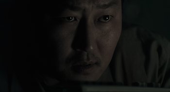 Movie still from “Memories of Murder” (2003), directed by Bong Joon Ho – A man's face in the dark; Close Up shot, Over the shoulder angle
