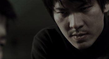 Movie still from “Memories of Murder” (2003), directed by Bong Joon Ho – A person with a black shirt on; Close Up shot, Low angle