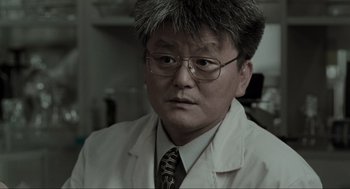 Movie still from “Memories of Murder” (2003), directed by Bong Joon Ho – A man in a white lab coat and a tie; Close Up shot, Over the shoulder angle