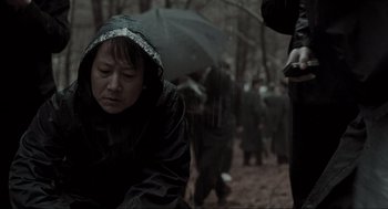 Movie still from “Memories of Murder” (2003), directed by Bong Joon Ho – A group of people walking through the woods with an umbrella; Close Up shot, Over the shoulder angle