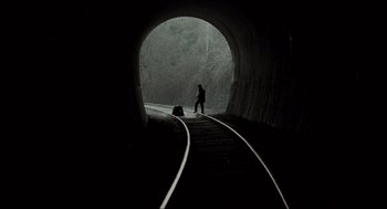 Movie still from “Memories of Murder” (2003), directed by Bong Joon Ho – A person walking down a train track in a tunnel; Extreme Wide shot, High angle