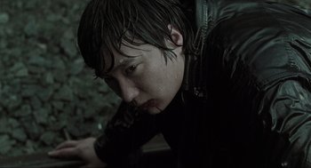 Movie still from “Memories of Murder” (2003), directed by Bong Joon Ho – A person with wet hair is leaning on a wall; Close Up shot, Low angle