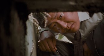 Movie still from “Memories of Murder” (2003), directed by Bong Joon Ho – A man holding a pair of scissors in his hand; Close Up shot, Low angle