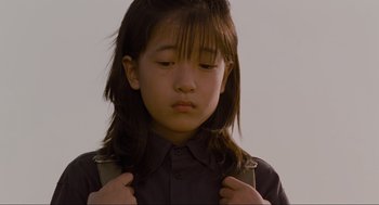 Movie still from “Memories of Murder” (2003), directed by Bong Joon Ho – A young girl with long black hair is holding her hands on her chest; Close Up shot, High angle