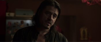 Movie still from “Memory” (2022), directed by Martin Campbell – A person with long black hair; Close Up shot, Over the shoulder angle