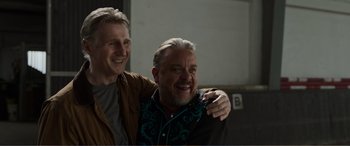 Movie still from “Memory” (2022), directed by Martin Campbell – A couple of men standing next to each other; Close Up shot, Low angle