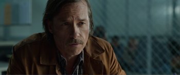 Movie still from “Memory” (2022), directed by Martin Campbell – A person wearing a jacket; Close Up shot, Over the shoulder angle