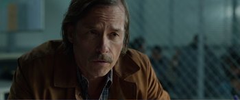 Movie still from “Memory” (2022), directed by Martin Campbell – A person wearing a jacket; Close Up shot, Over the shoulder angle