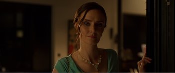 Movie still from “Memory” (2022), directed by Martin Campbell – A person wearing a necklace; Close Up shot, Over the shoulder angle