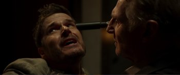 Movie still from “Memory” (2022), directed by Martin Campbell – A man is looking at another man's face; Close Up shot, Over the shoulder angle