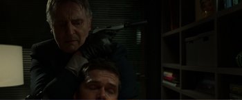 Movie still from “Memory” (2022), directed by Martin Campbell – A man is getting his head shaved by another man; Close Up shot, Over the shoulder angle