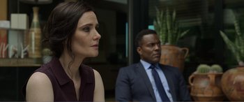 Movie still from “Memory” (2022), directed by Martin Campbell – A woman and a man in a suit and tie; Close Up shot, Over the shoulder angle