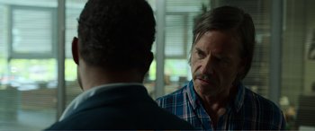 Movie still from “Memory” (2022), directed by Martin Campbell – A man in plaid shirt talking to another man in plaid shirt; Close Up shot, Over the shoulder angle