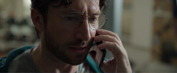 Movie still from “Memory” (2022), directed by Martin Campbell – A person talking on a cell phone; Close Up shot, Low angle
