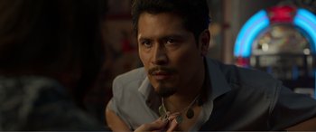 Movie still from “Memory” (2022), directed by Martin Campbell – A person wearing a necklace; Close Up shot, Over the shoulder angle