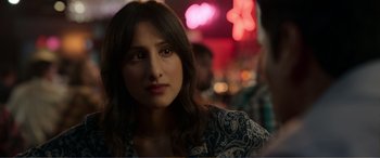 Movie still from “Memory” (2022), directed by Martin Campbell – A person sitting in front of lights; Close Up shot, Over the shoulder angle