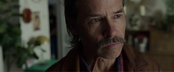 Movie still from “Memory” (2022), directed by Martin Campbell – A person with a mustache; Close Up shot, Over the shoulder angle