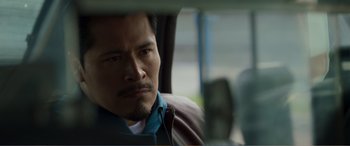 Movie still from “Memory” (2022), directed by Martin Campbell – A person sitting in a car; Close Up shot, Over the shoulder angle