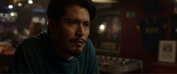 Movie still from “Memory” (2022), directed by Martin Campbell – A person wearing a blue shirt; Close Up shot, Over the shoulder angle