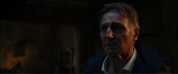 Movie still from “Memory” (2022), directed by Martin Campbell – A person looking at the camera; Close Up shot, Low angle