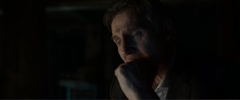 Movie still from “Memory” (2022), directed by Martin Campbell – A person with his hand on his chin; Close Up shot, Over the shoulder angle