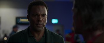 Movie still from “Memory” (2022), directed by Martin Campbell – A person wearing a green jacket; Close Up shot, Over the shoulder angle