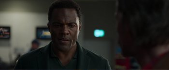 Movie still from “Memory” (2022), directed by Martin Campbell – A person wearing a suit and tie; Close Up shot, Over the shoulder angle