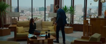 Movie still from “Memory” (2022), directed by Martin Campbell – A man and a woman are in a living room; Wide shot, Over the shoulder angle