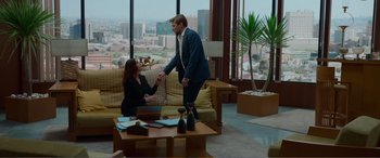 Movie still from “Memory” (2022), directed by Martin Campbell – A man and a woman shaking hands in a living room; Wide shot, Over the shoulder angle