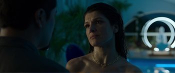 Movie still from “Memory” (2022), directed by Martin Campbell – A woman with a necklace looking at the camera; Close Up shot, Over the shoulder angle