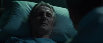 Movie still from “Memory” (2022), directed by Martin Campbell – A person laying in a hospital bed; Close Up shot, Low angle