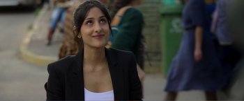 Movie still from “Memory” (2022), directed by Martin Campbell – A woman in a white shirt and a black jacket; Close Up shot, Over the shoulder angle